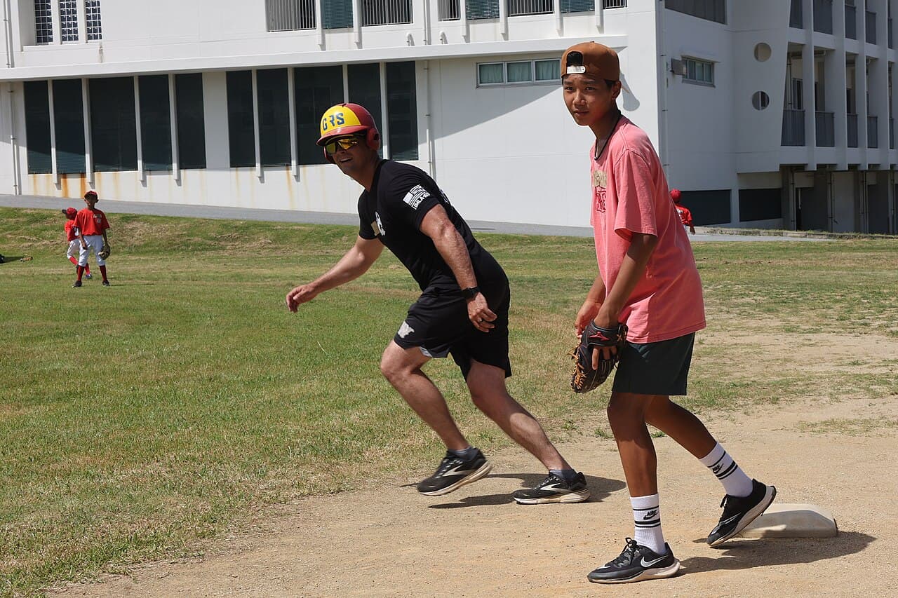A coach and young players during a community baseball game