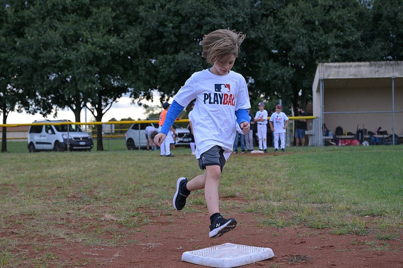 A young player rounding the bases during a youth baseball game